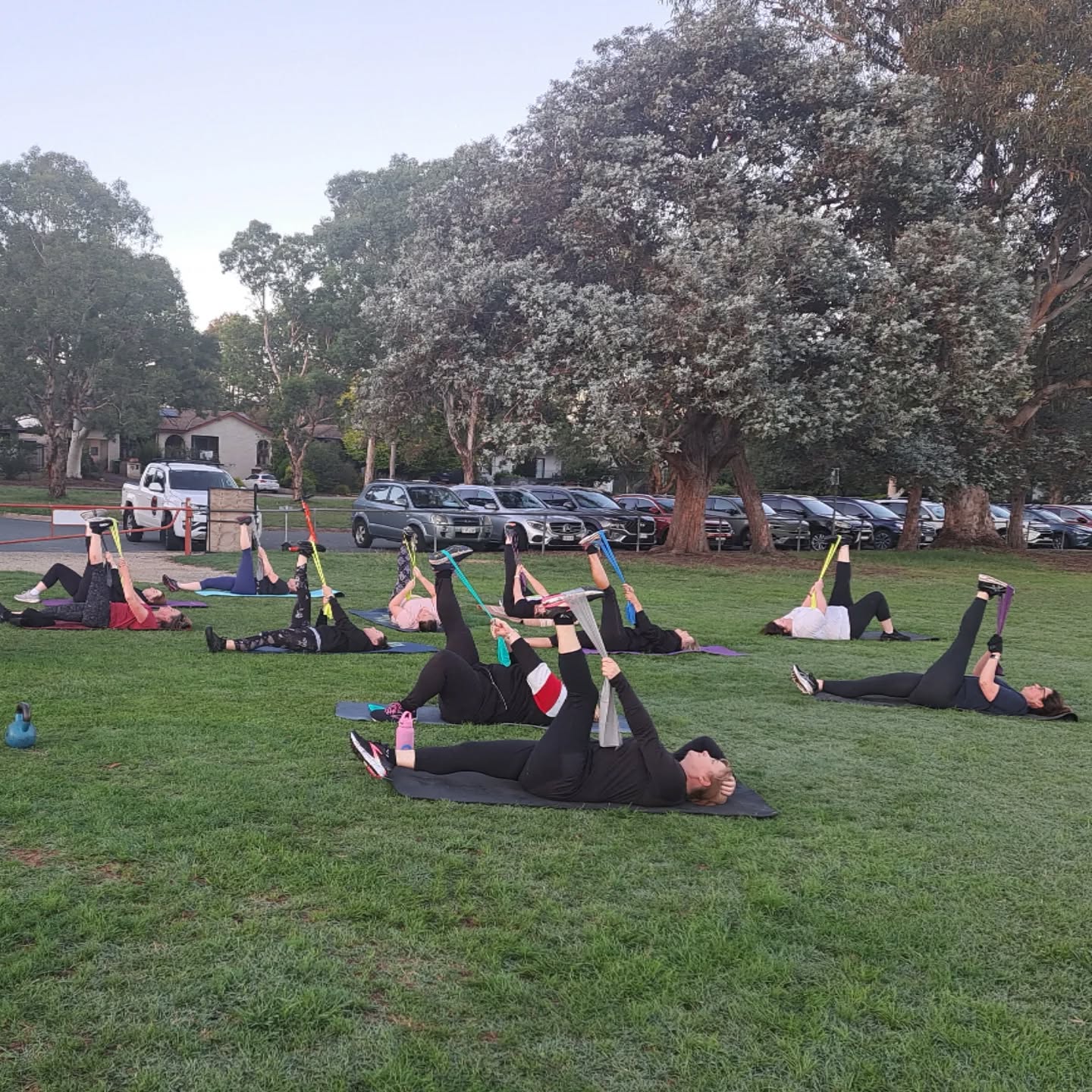 Women stretching together during group personal training in a Canberra park
